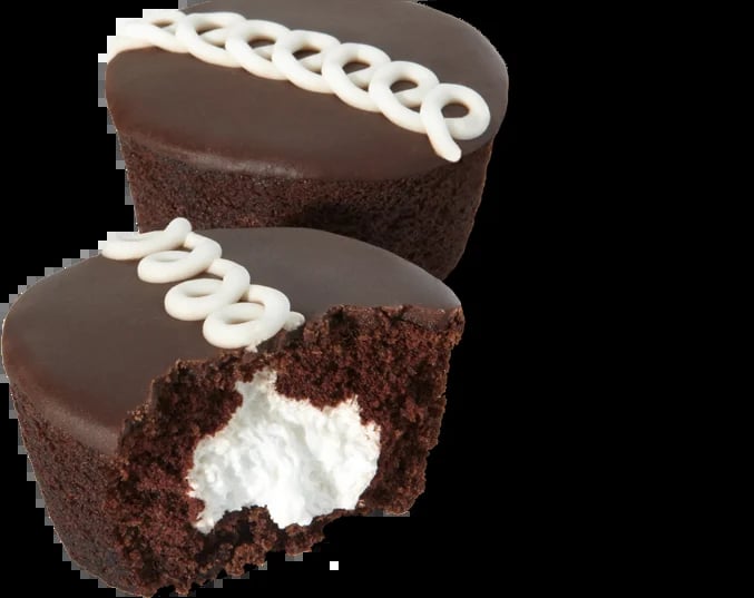 Two chocolate cupcakes with white frosting piped on top, one cut in half revealing white cream filling inside.